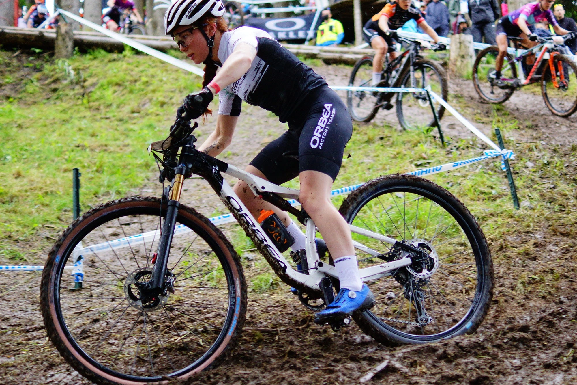Závodnice na XC horském kole s koly HUNT Race XC MTB 29 v bahnité zatáčce během závodu