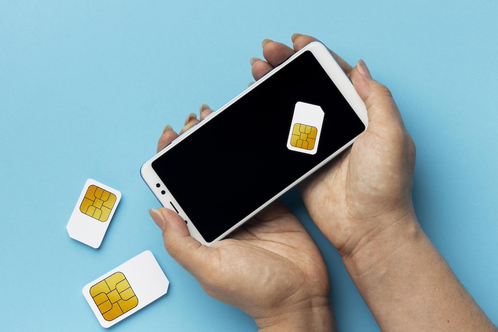 front-view-hands-holding-smartphone-sim-cards