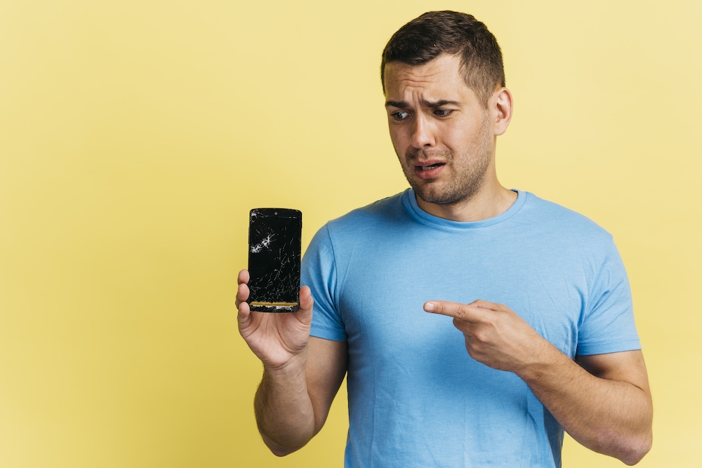 man-holding-broken-phone