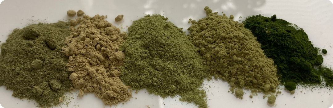 Porovnání pěti zelených prášků různého odstínu vedle sebe
