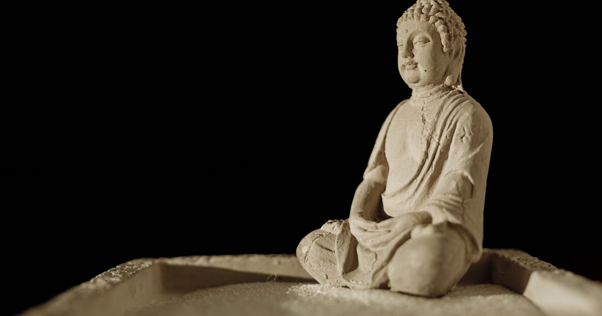 Mosadzná socha sediaceho Budhu v meditatívnej póze ako pokojný dekoratívny prvok domáceho interiéru