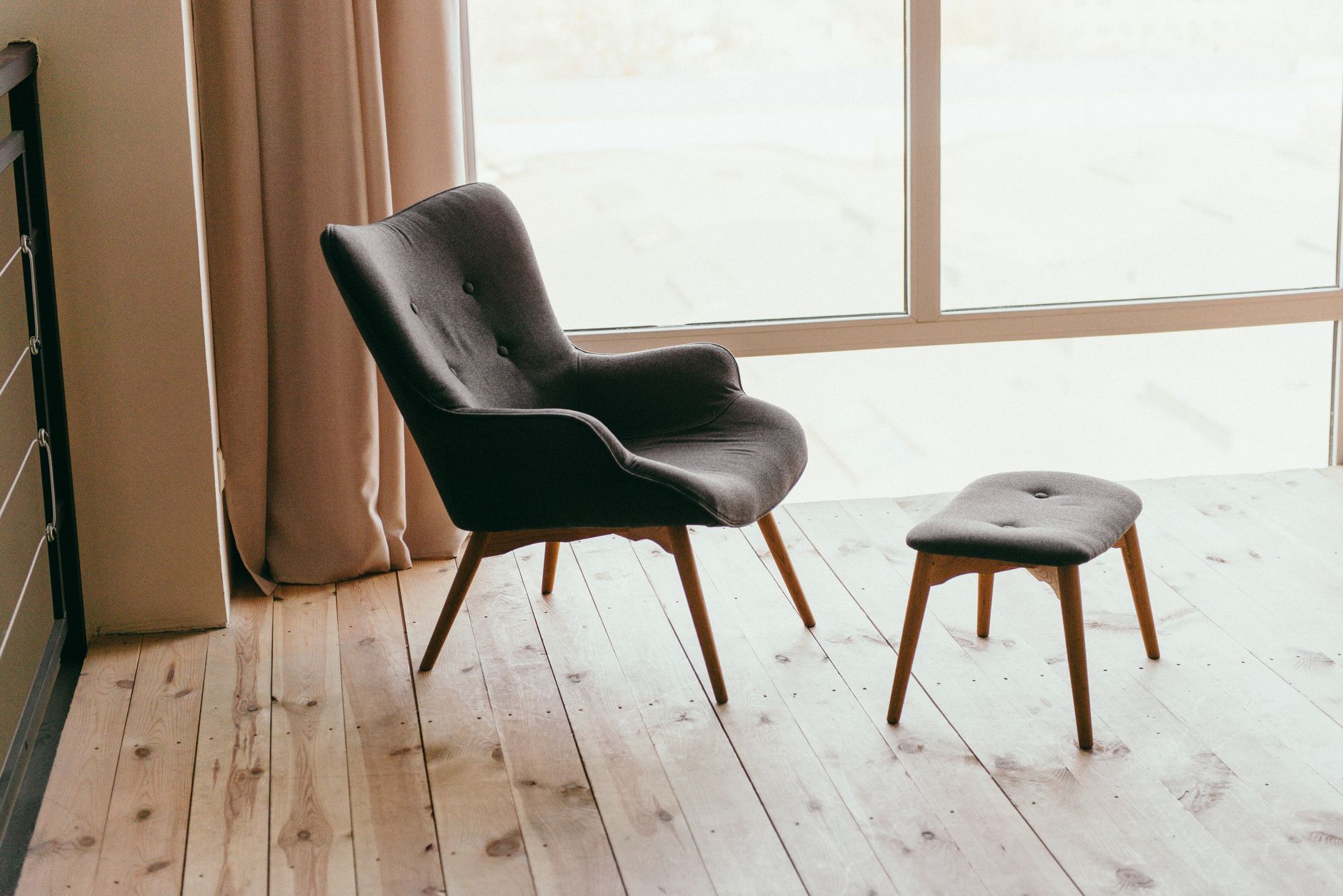 Moderné relaxačné kreslo s podnožkou v presvetlenom minimalistickom interiéri