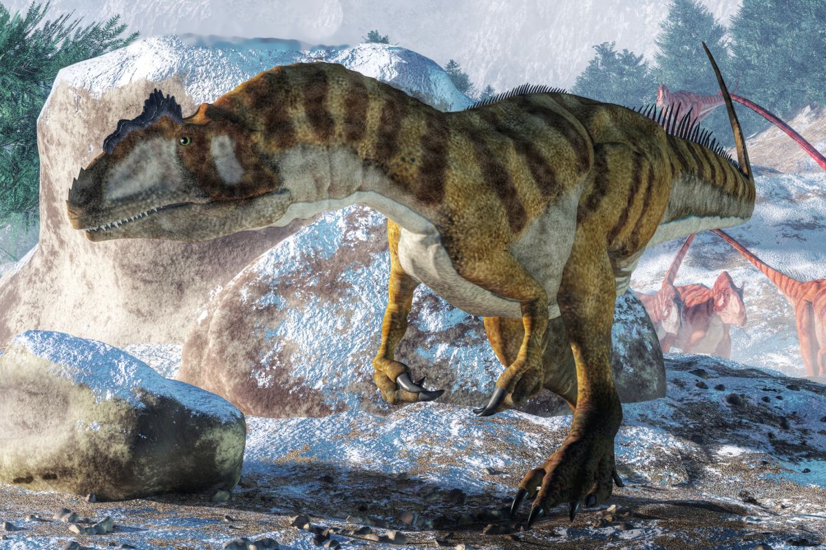 Velký Allosaurus se prochází po horách, za ním následuje několik dalších dinosaurů.