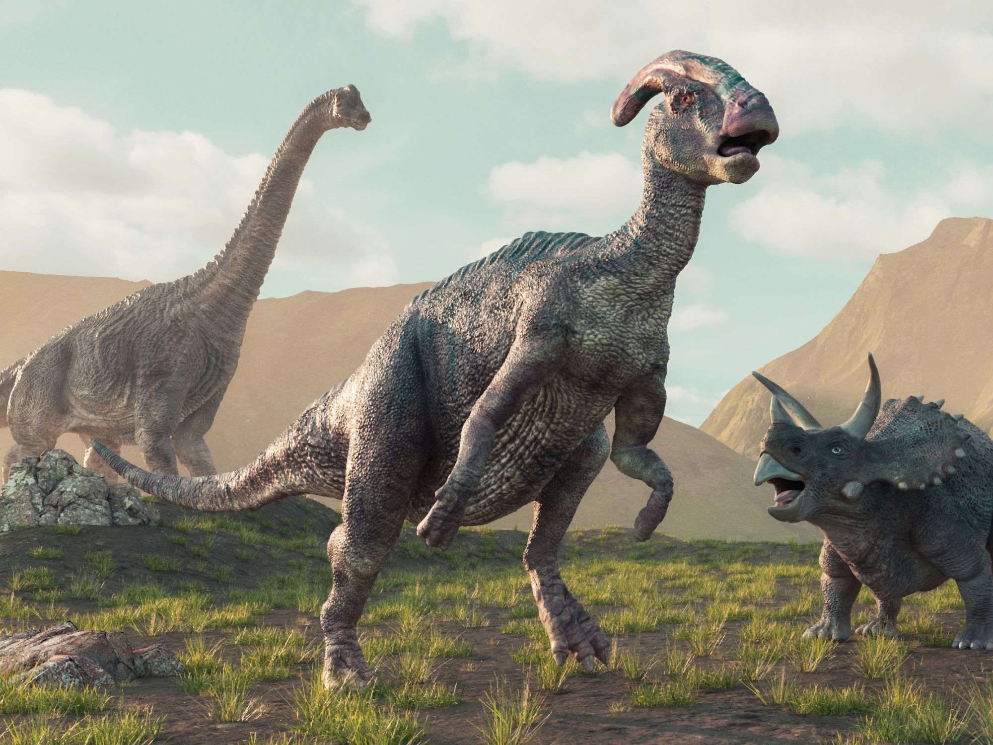 Skupina různých druhů dinosaurů v pravěké krajině.