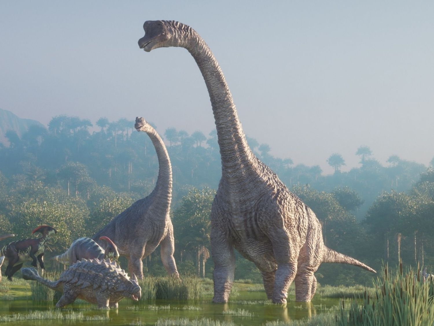 Skupina dinosaurů kráčí pravěkou krajinou.