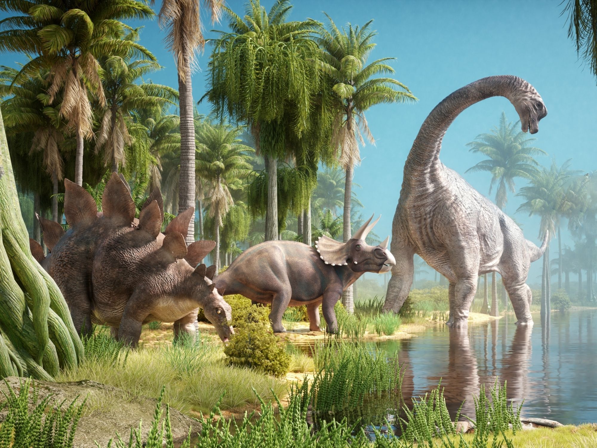 Pravěká scéna s několika býložravými dinosaury u vody, ilustrace k tématu délky života dinosaurů.