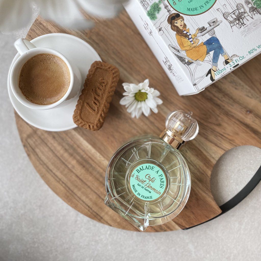 Editoriál — francouzská parfémovaná voda Café à Saint Germain na dřevěném tácu vedle šálku espressa a sušenky, každodenní francouzská nálada