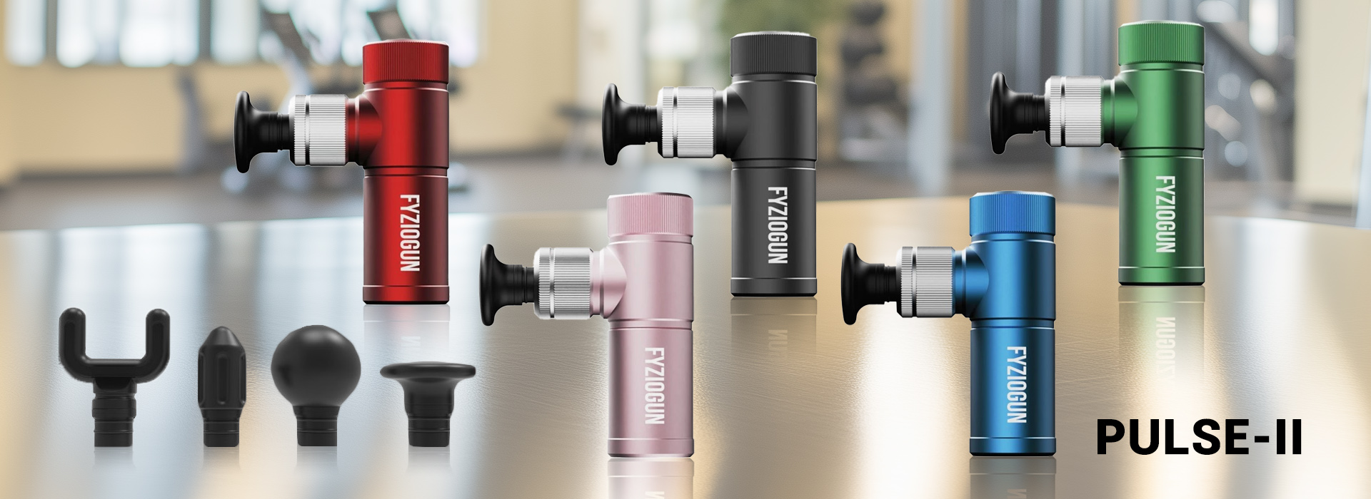 Produktová fotografia mini masážnej pištole Fyziogun Pulse-II. Na obrázku je zobrazených päť farebných variantov (červená, ružová, čierna, modrá a zelená) spolu so štyrmi špeciálnymi masážnymi hlavicami: vidlicová, kužeľová, guľovitá a plochá.