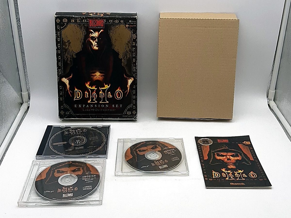 Big box Diablo II: Lord of Destruction v českém vydání, vedle něj vnitřní kartonová vložka, tři CD v pouzdrech a manuál