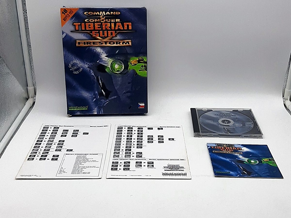 Big box Command and Conquer: Tiberian Sun Firestorm s českou vlaječkou, vedle něj disk v pouzdře a dvě kartonové přehledové karty
