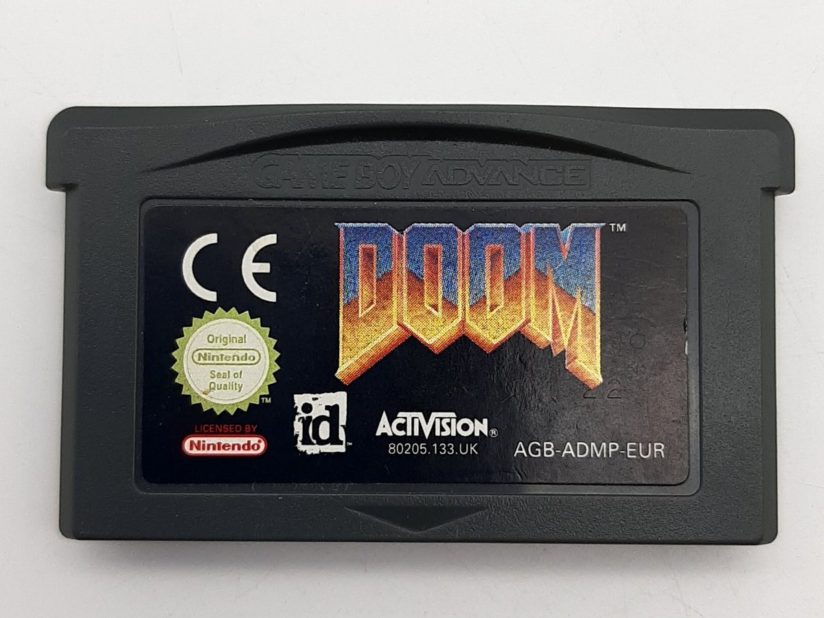 Kazeta Doom pro Game Boy Advance — černý kartridž s logem DOOM, znaky id Software a Activision a kódem AGB-ADMP-EUR