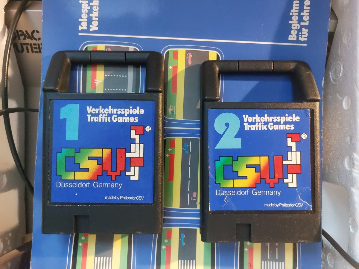 Kazety Verkehrsspiele Traffic Games 1 a 2 s logem CSV Düsseldorf Germany ležící na modré metodice pro učitele