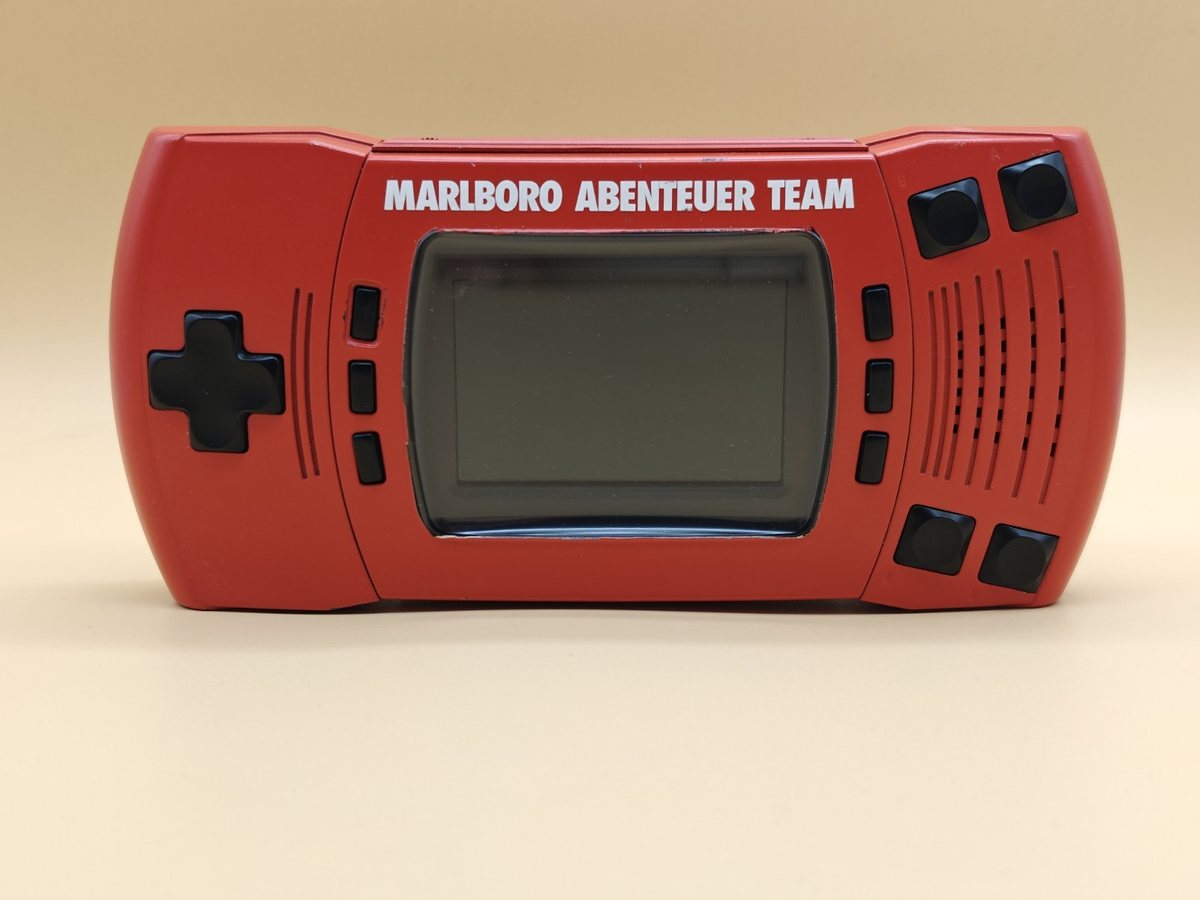 Červený Atari Lynx II s bílým nápisem Marlboro Abenteuer Team nad displejem