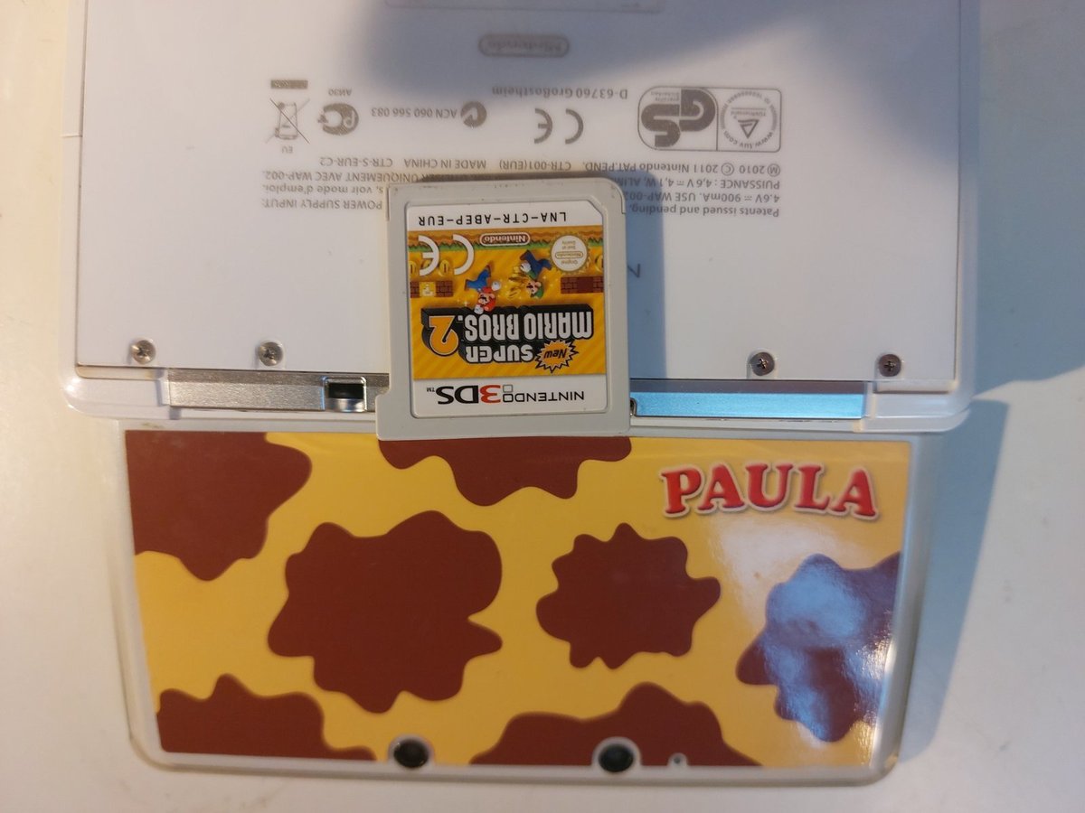 Otevřené Nintendo 3DS Paula s kartou hry New Super Mario Bros. 2
