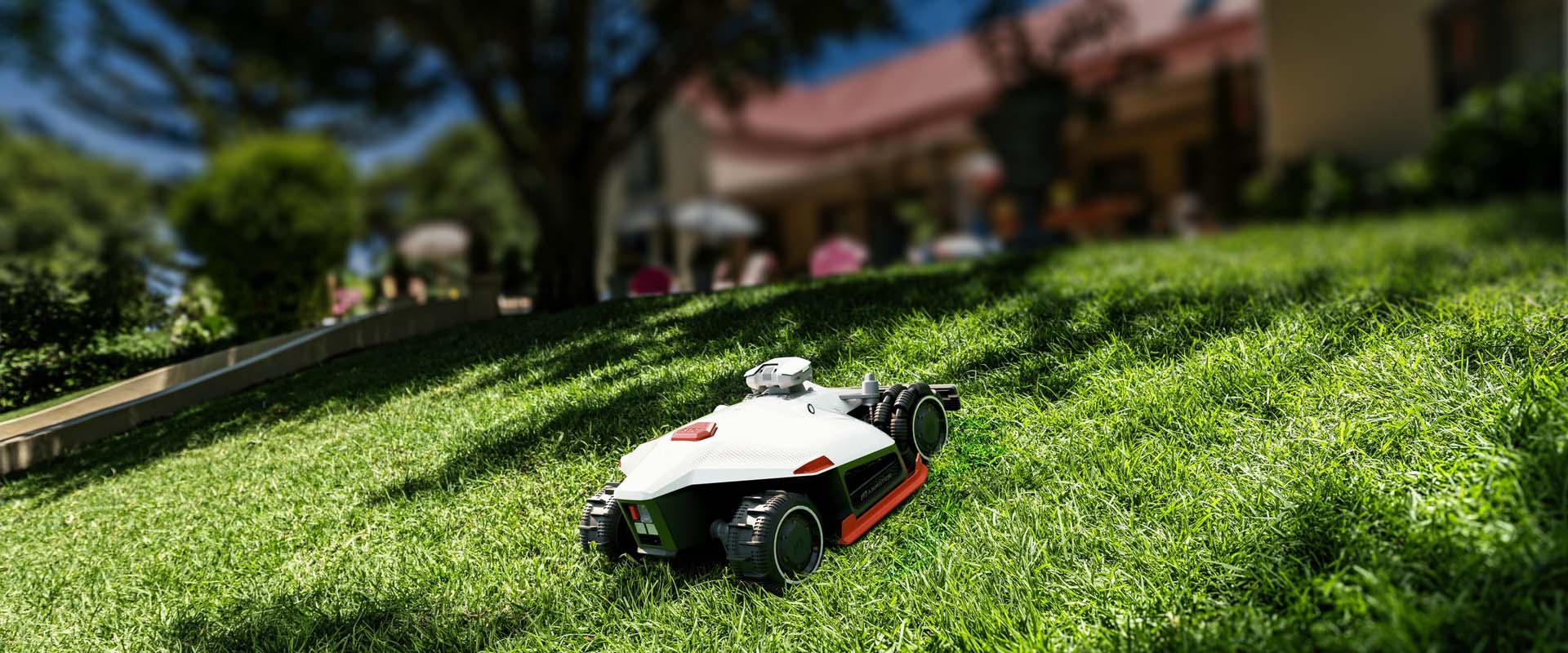 ChatGPT povedal: Robotická kosačka Mammotion Luba 2 AWD kosiaca hustý zelený trávnik na svahu pred domom, s pohonom všetkých kolies pre zvládnutie náročného terénu.