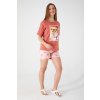Dámsky letný set Paradise Found – predný pohľad na modelku v tričku s potlačou a ružových šortkách s palmami