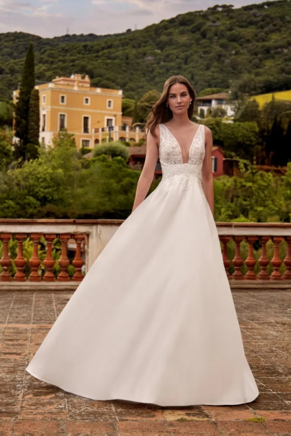 svatebni saty aretusa kolekce nicole colet by pronovias 2026 objemna sukne hluboky vystrih hladka sukne siroka raminka