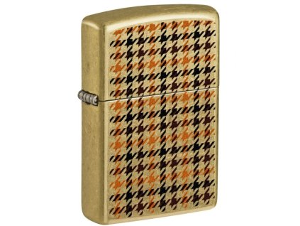 Mosazný zapalovač Zippo s opotřebovaným vzhledem a černým kostkovaným potiskem.