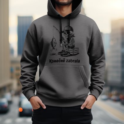 Pánská mikina s kapucí v ocelově šedé barvě s černým vtipným potiskem kostlivce sedícího u vody, který chytil rybu, a nápisem "Konečně zabrala".