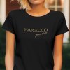 černé dámské tričko s krátkým rukávem a kulatým výstřihem. Uprostřed trička je zlatým písmem napsáno "PROSECCO" a pod ním menším a elegantnějším písmem "prosim".