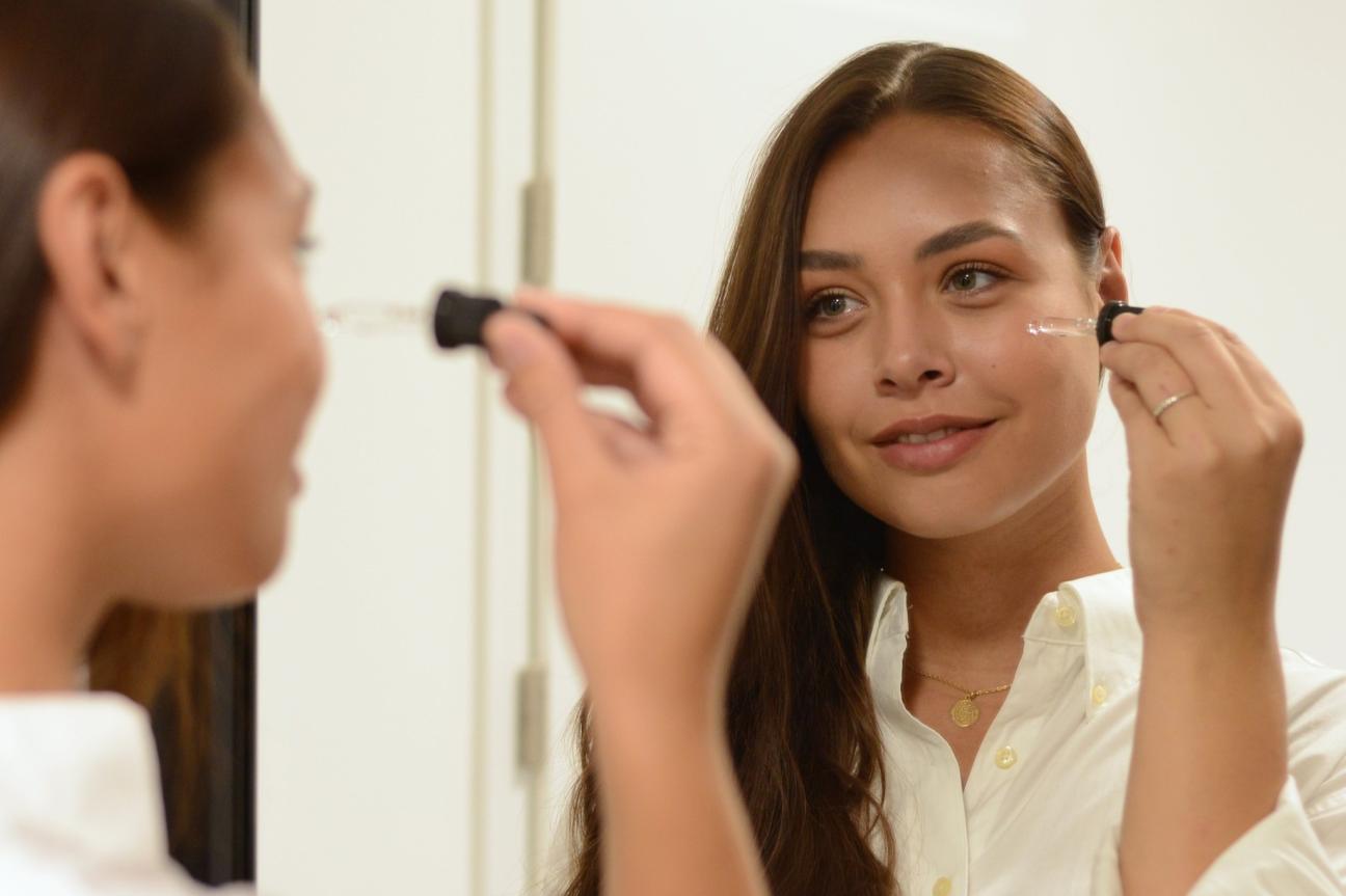 Žena, která si nanáší sérum na pleť