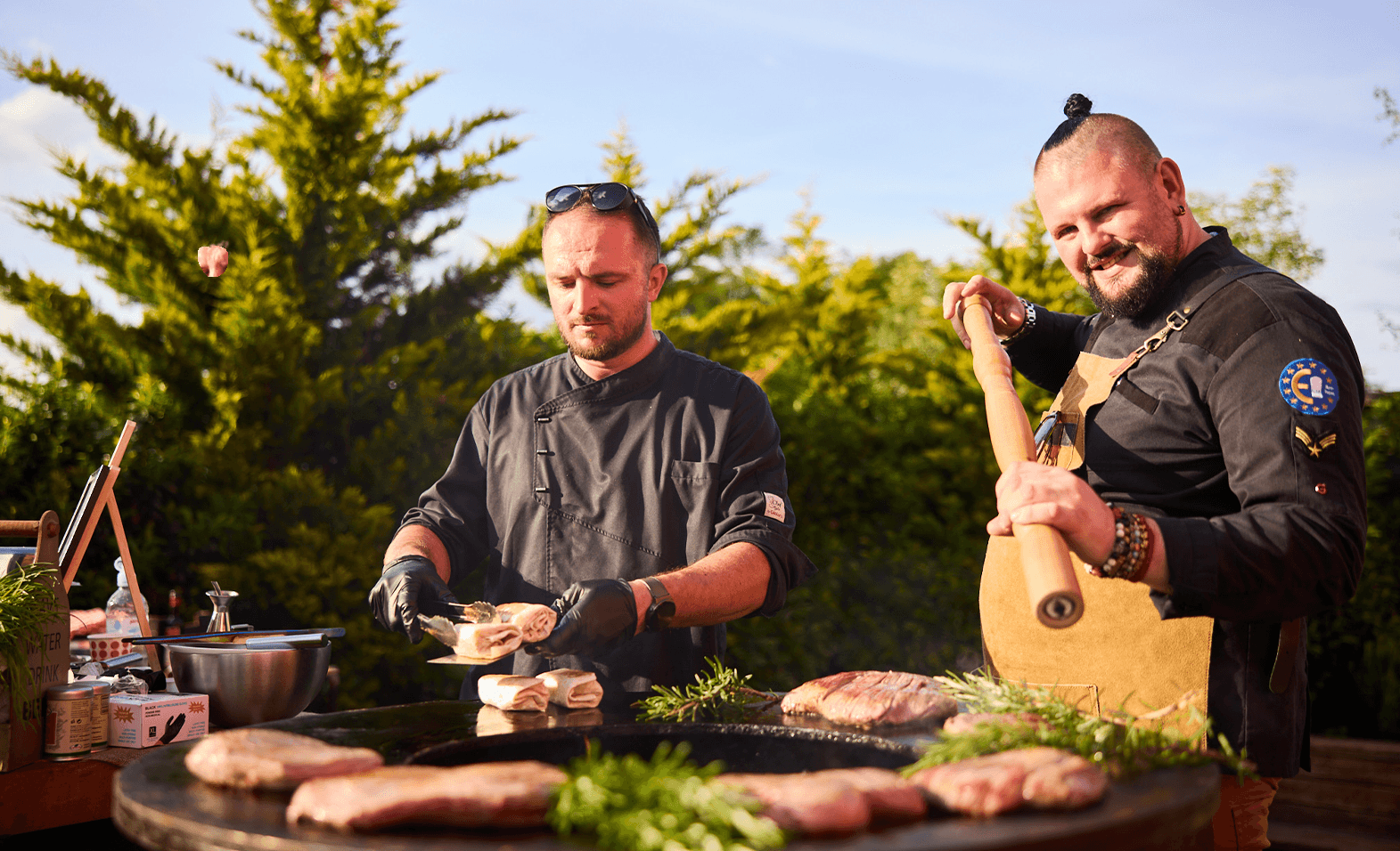 Šéfkuchári GRILO BBQ SHOW pri príprave steakov na ohniskovom grile OFYR