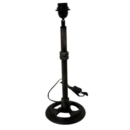 Lampa s robustním kovaným podstavcem, který dodává prostoru industriální šarm.