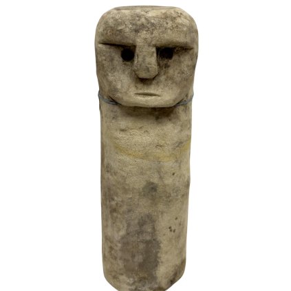 Podlouhlá kamenná soška s jemně vytesaným obličejem na jednom konci.