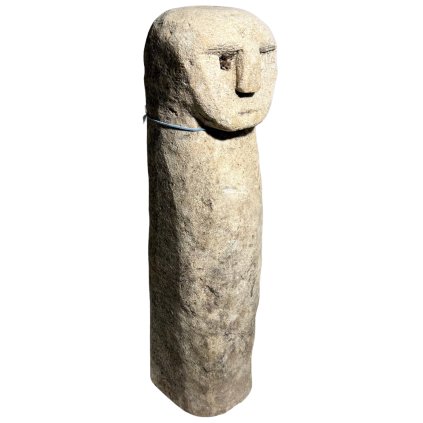 Podlouhlá kamenná soška s jemně vytesaným obličejem na jednom konci.