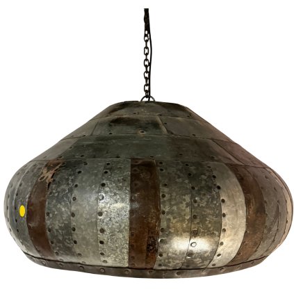 Závěsná lampa vytvořená spojenými kusy kovu v patchworkovém stylu, která přináší industriální a kreativní vzhled.