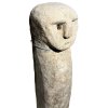 Podlouhlá kamenná soška s jemně vytesaným obličejem na jednom konci.