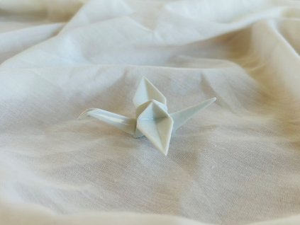 bílý porcelánový origami jeřáb stojící