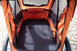  Kočárek pro psy s 38cm kolečky a nosností až 30 kg. Rozměry kabiny 72 × 45 × 60 cm, možnost připevnění upravovacího stolku. Barva černo-oranžová. Detail kabiny.