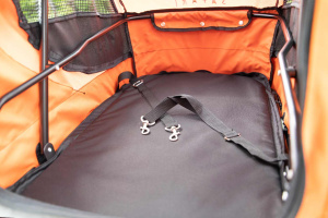  Kočárek pro psy s 38cm kolečky a nosností až 30 kg. Rozměry kabiny 72 × 45 × 60 cm, možnost připevnění upravovacího stolku. Barva černo-oranžová. Detail kabiny.