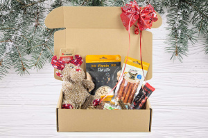 Vánoční dárkový box „Sob s vánoční čepičkou“ – plyšová pískací hračka, gumový míček a výběr oblíbených psích pamlsků v krásném dárkovém balení