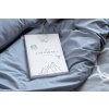 mockup featuring a paperback book placed on a cozy bed 33909