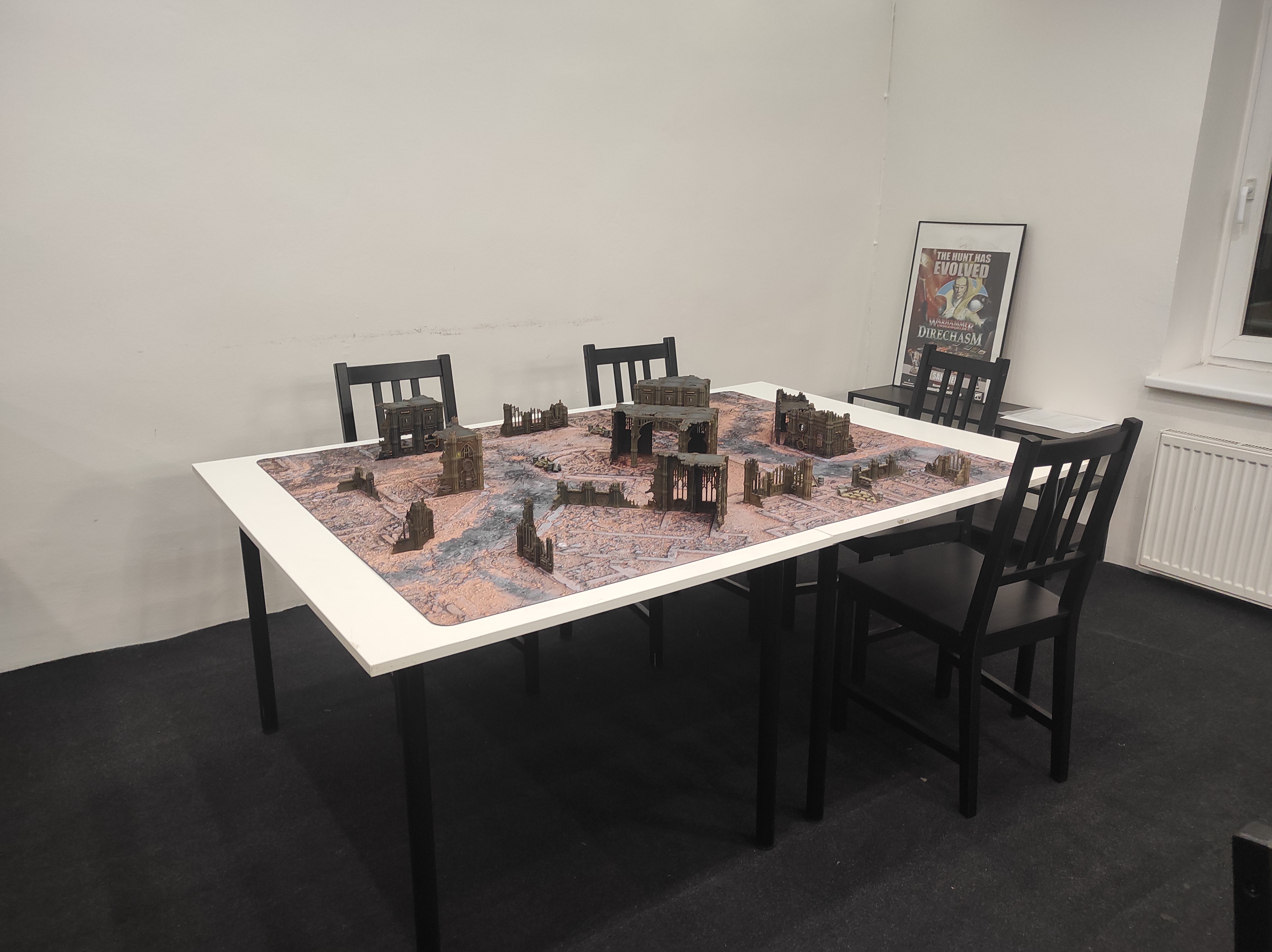 Stůl pro hry od Games Workshop s terény v prodejní místnosti