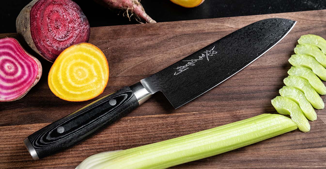 Nůž Ran Plus Santoku položený na prkénku