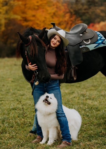Laura s koňom vo westernovom sedle a psom plemena samojed na jesennej lúke