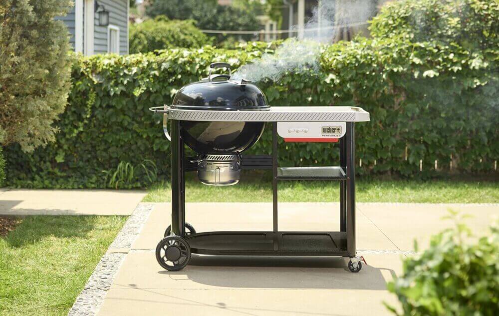 performer-premium-gril-na-drevene-uhlie-57-cm-weber-v-zahrade