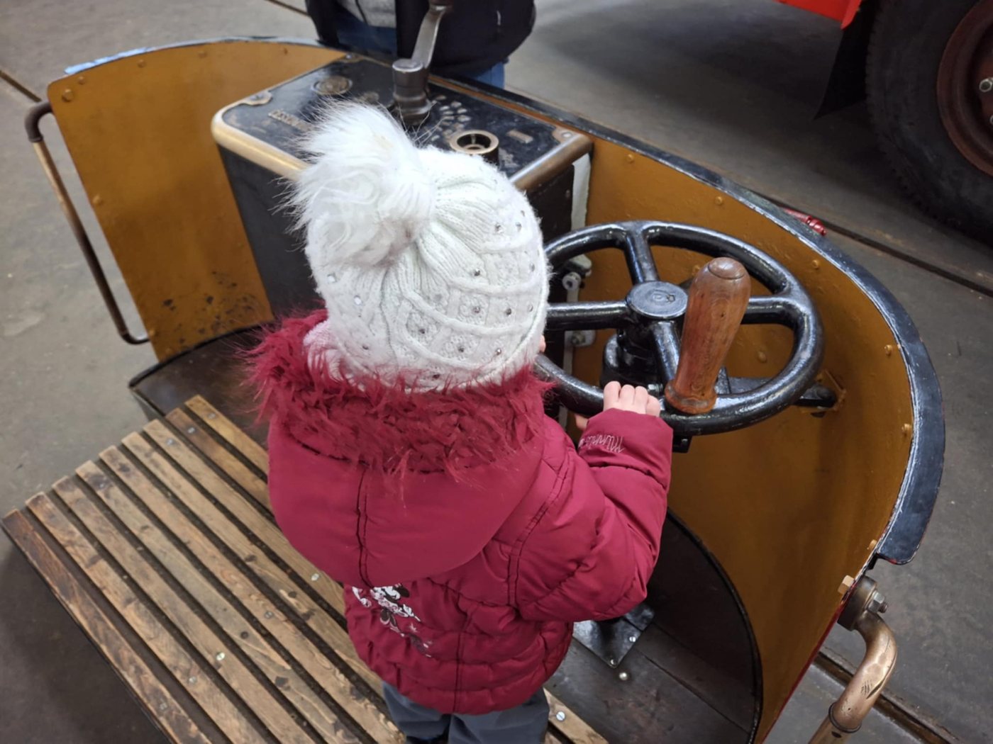 Holčička zezadu u ovládání otevřeného tramvajového vozu