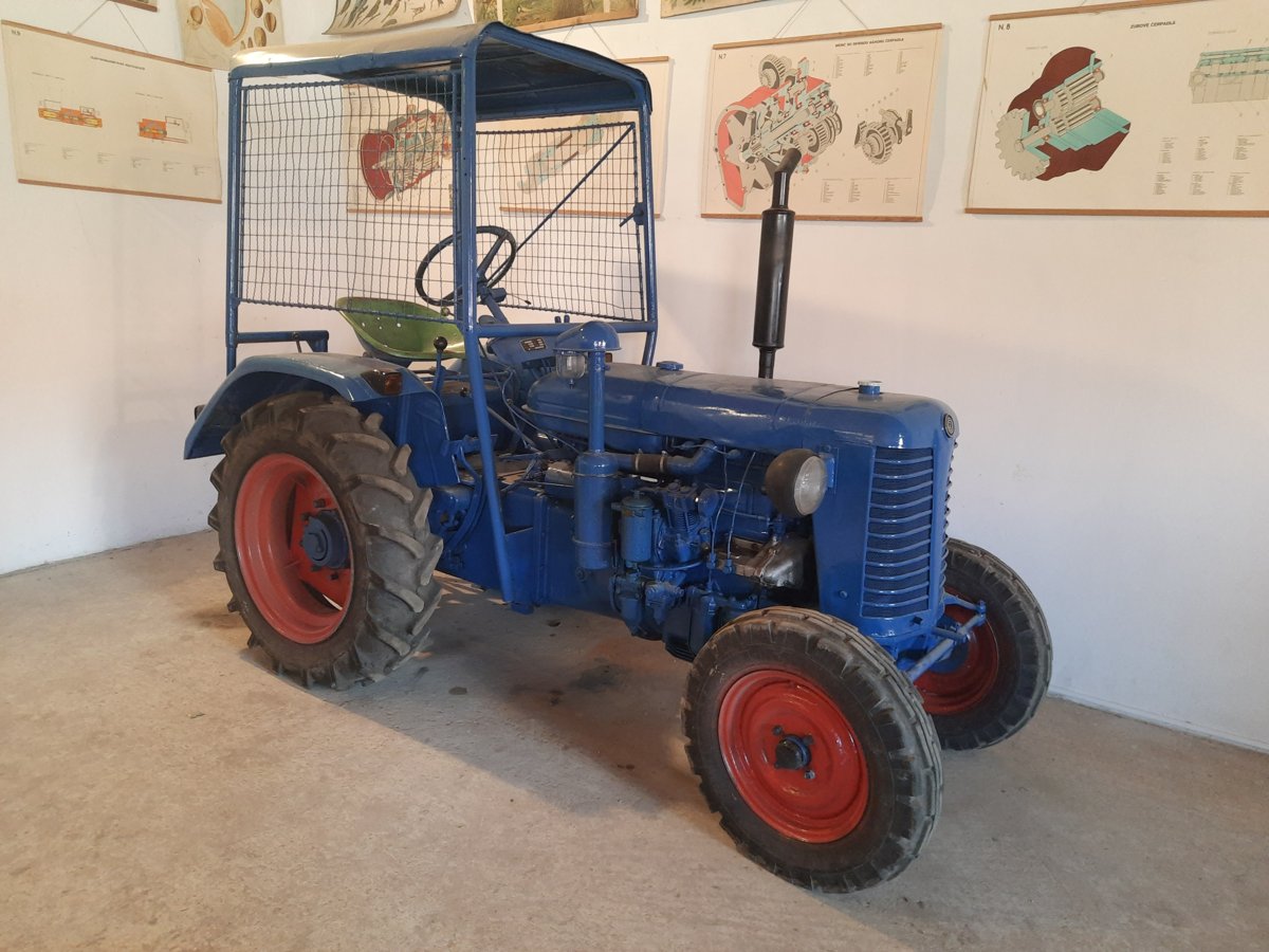 Modrý historický traktor s ochranným rámem v Chotouni