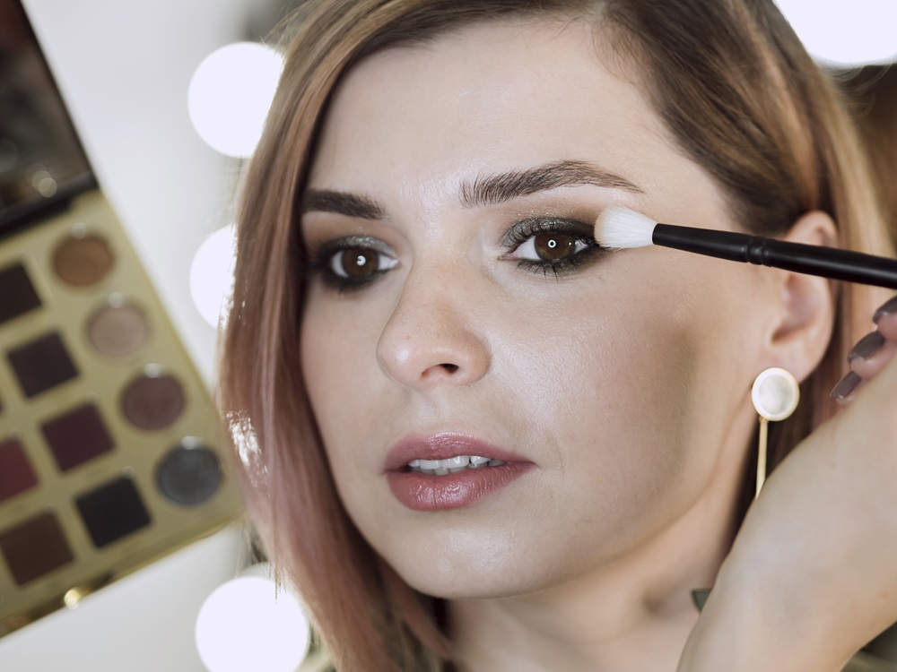 artist-applying-make-up-beautiful-woman