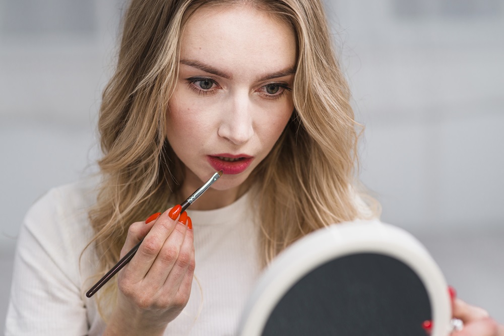 woman-doing-lip-makeup-with-mirror
