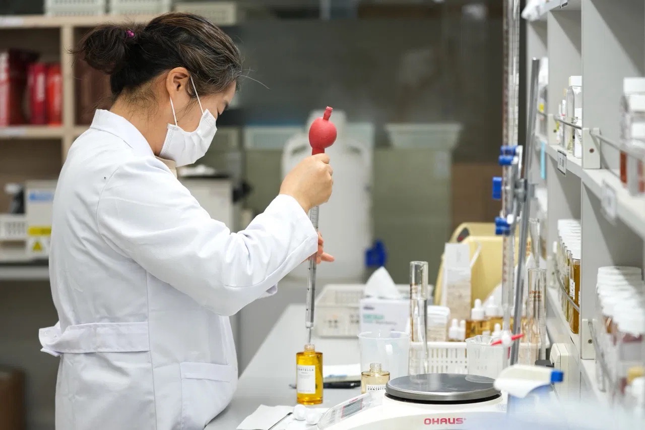 Laboratoř SR Biotek — vědkyně pipetuje vzorek