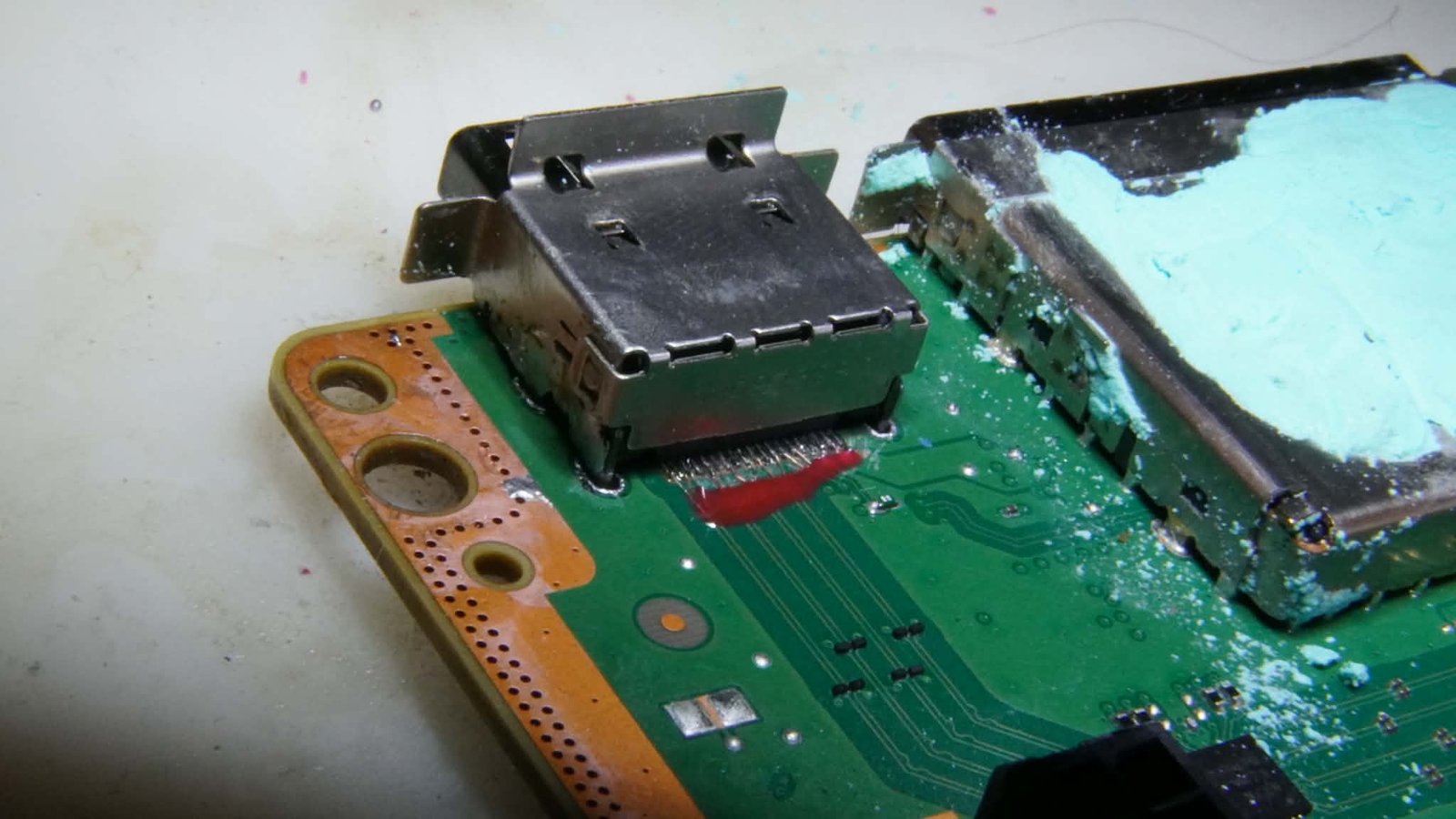 Poškodený HDMI/USB konektor s koróziou na doske – pred výmenou