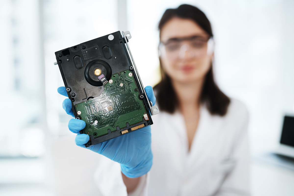 Paní drží v ruce HDD disk.