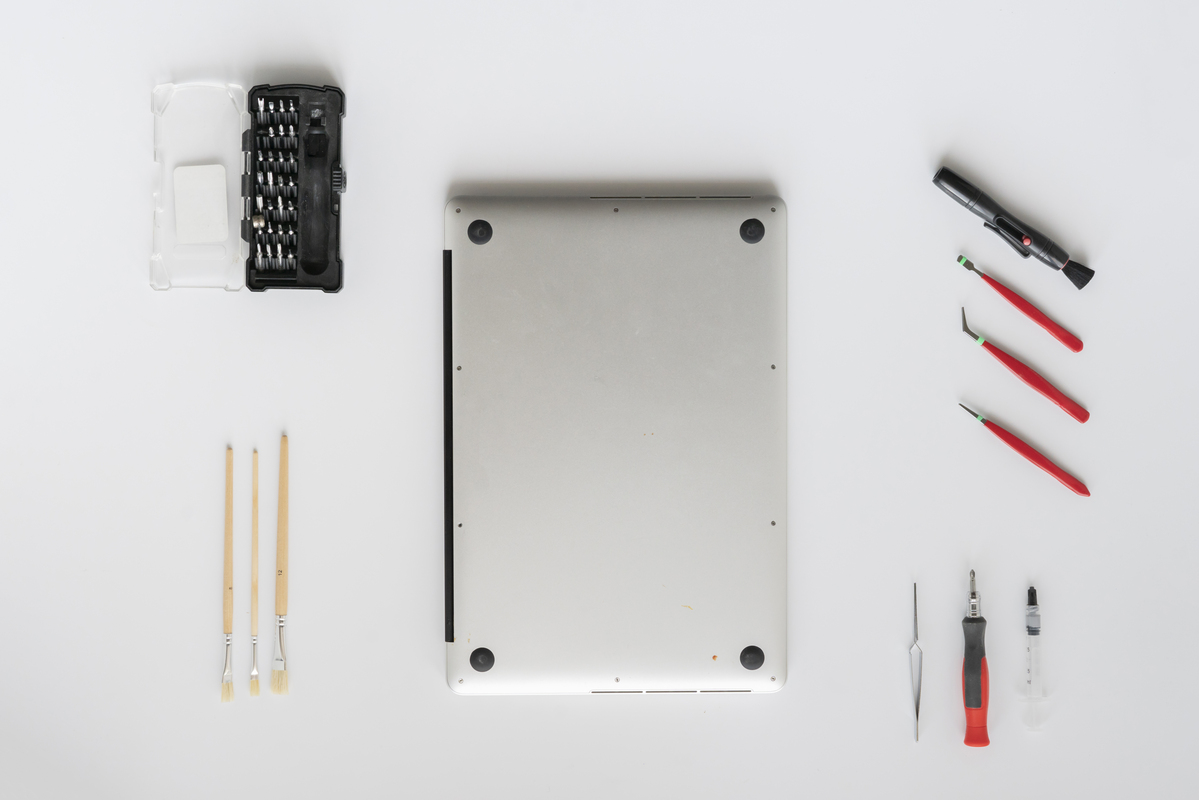 Notebook z vrchu ležiaci na stole, okolo neho sú profesionálne pomôcky.