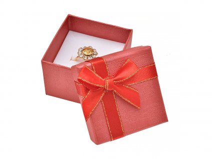 Červená papierová krabička s mašľou so zlatým okrajom na prsteň alebo náušnice