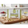 Create a nice image in a healthy snack setting with the pistachio and white chocolate protein cookie